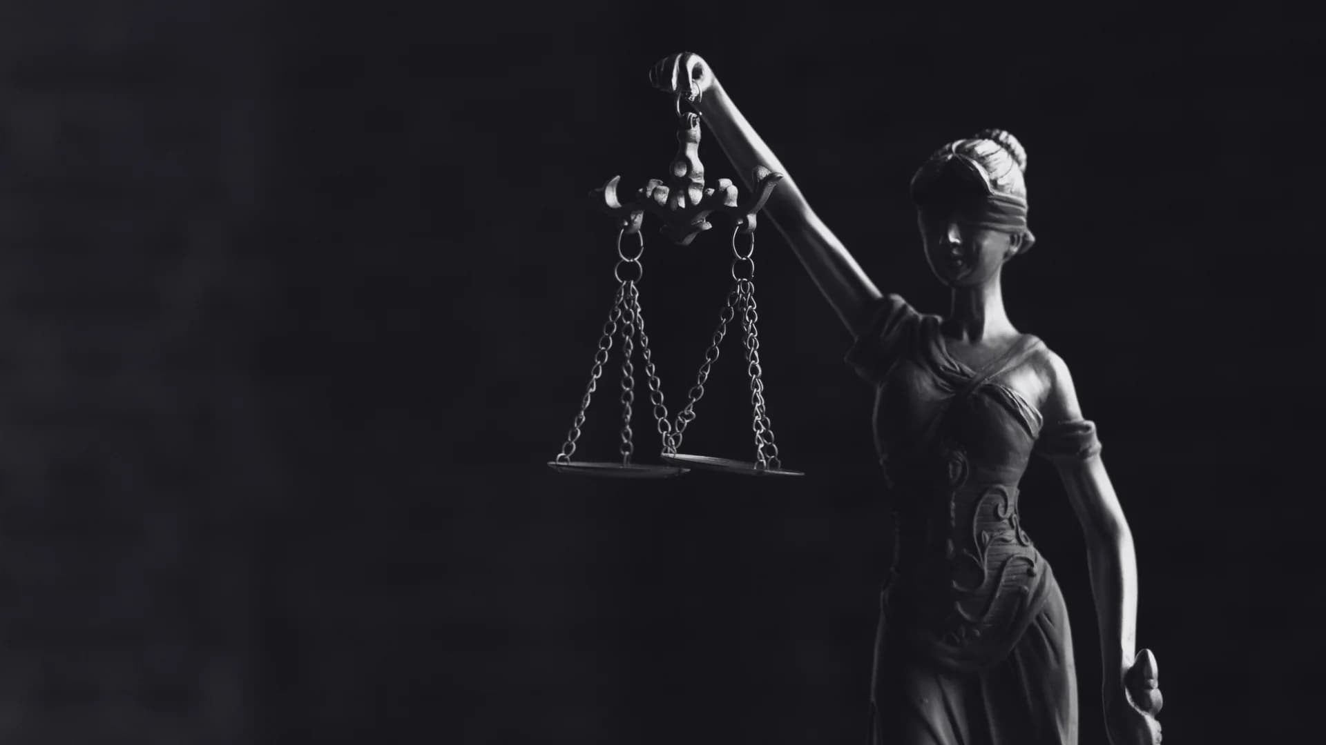 Escultura clássica da justiça com a espada e a balança, simbolizando o pilar estratégico da advocacia